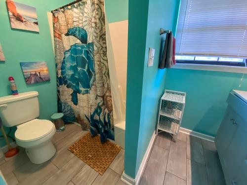 La salle de bains est pourvue de toilettes et d'un rideau de douche. dans l'établissement Pool-Spacious, Main House Haven, à Pensacola