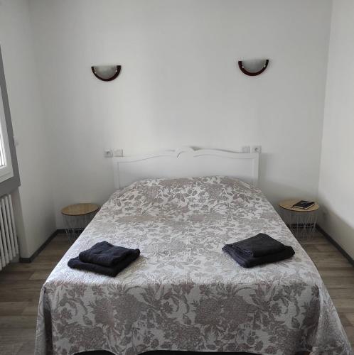 a bedroom with a bed with two black towels on it at studio 30m2 in Arles