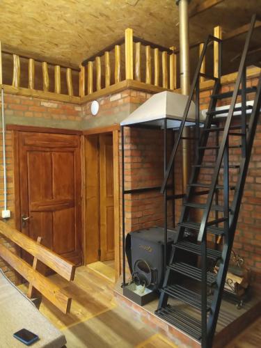 a room with a stove and a spiral staircase at Шаленарозі in Migovo