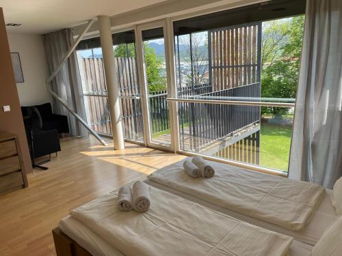 a bedroom with two beds in front of a large window at JD Apartment in Liptovský Mikuláš