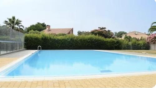 une grande piscine bleue devant une maison dans l'établissement Logement Coquelicot, à Saint-Cyprien