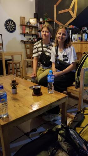 two women sitting on chairs next to a table at CoffeeBunk Hostel in Tangerang