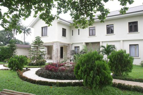 a large white house with a large garden in front of it at Clear Essence California Spa & Wellness Resort in Lagos