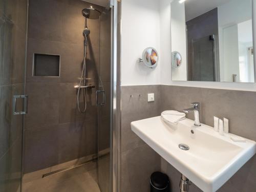 a bathroom with a sink and a shower at Inselsünn Hotel und Apartments in Spiekeroog