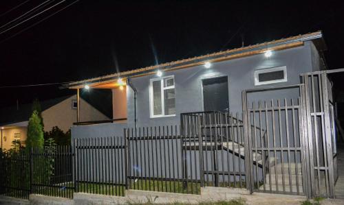 a small white house with a gate at night at Sunny Lodge Dilijan in Dilijan