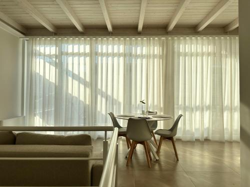 ein Esszimmer mit einem Tisch, Stühlen und einem Fenster in der Unterkunft Bottego24 Suite, Apartment & Terrace in Nardò