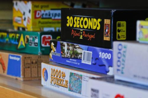 a stack of board games on a shelf in a store at Domaine La Faix, Gite la Forestière in Saint-Plaisir