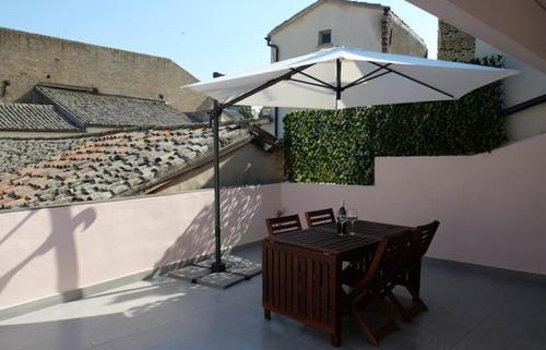 a patio with an umbrella and a table and chairs at Il Timbro - Dimore Diffuse in Vasto