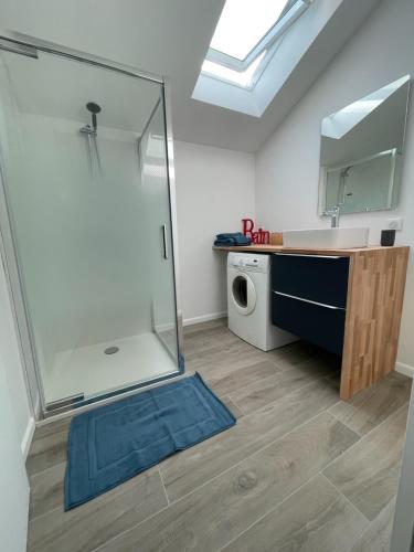 een badkamer met een douche, een wastafel en een wasmachine bij Gîte Le Ballandeau in Ballan-Miré