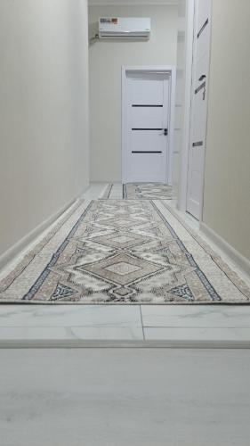 a hallway with a rug on the floor and a door at Begzod's house in Samarkand