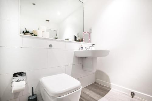 biała łazienka z toaletą i umywalką w obiekcie Grandeur 3 Bedroom Flat in London, Mayfair HY3 w Londynie