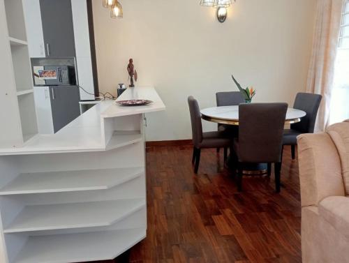 een keuken en eetkamer met een tafel en stoelen bij BomaBnB Holiday Homes in Nairobi