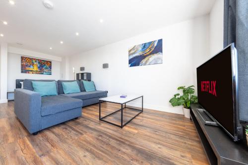 a living room with a couch and a tv at 4 West London Brand New Loft in London
