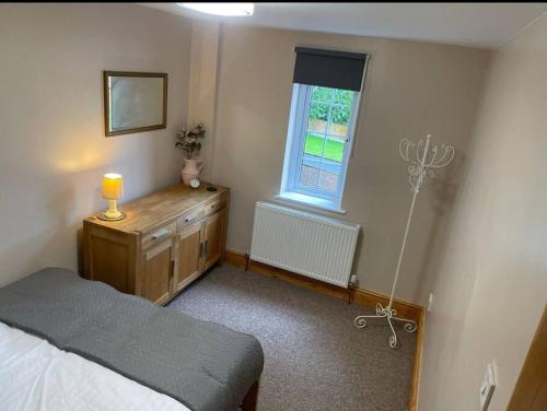 a bedroom with a bed and a window at Netherton Studio Apartment 2 in Llandrillo-yn-Rhôs