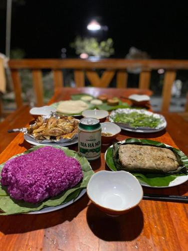 a wooden table with plates of food on it at Hali Home Moc Chau in Mộc Châu