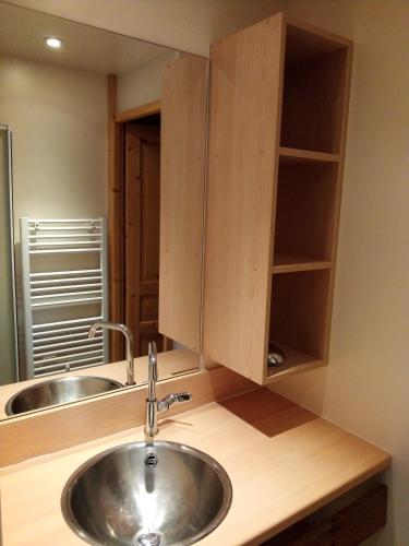 - un comptoir de cuisine avec un évier et un miroir dans l'établissement Les Chalets du Haut-Forez, à Usson-en-Forez