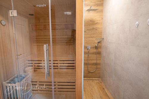 La salle de bains est pourvue d'une douche avec une porte en verre. dans l'établissement Island Villa Adriana with heated pool and sauna, à Lun
