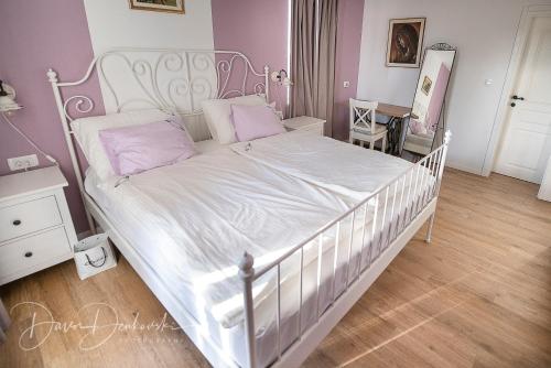 ein Schlafzimmer mit einem weißen Bett mit einem weißen Rahmen in der Unterkunft Island Villa Adriana with heated pool and sauna in Lun