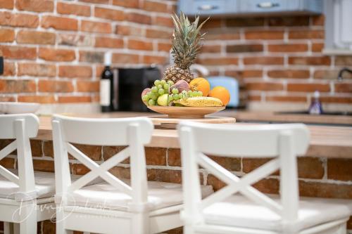 a bowl of fruit on a table with two chairs at Island Villa Adriana with heated pool and sauna in Lun