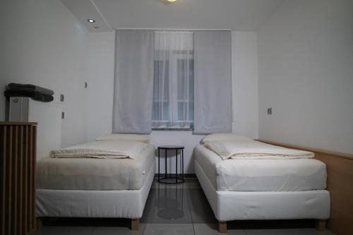 2 camas individuales en una habitación con ventana en Dreams im Erdgeschoss en Koetz 