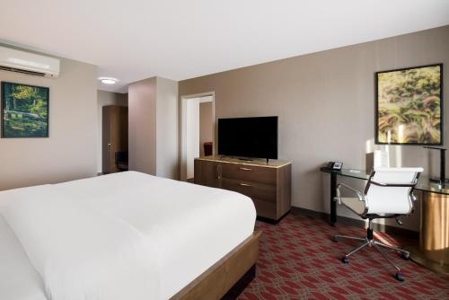 a hotel room with a bed and a desk and a television at Hotel 11, MOD A Sonesta Collection in Calgary