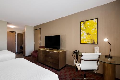 a hotel room with a bed and a desk and a television at Hotel 11, MOD A Sonesta Collection in Calgary