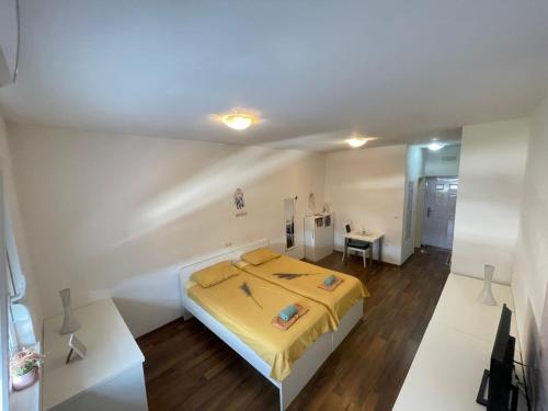 1 dormitorio con 1 cama con manta amarilla en City Apartments, en Mostar