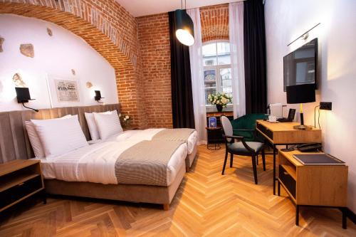 sypialnia z łóżkiem, biurkiem i telewizorem w obiekcie HOTEL TEATR w Krakowie