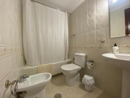 Baño blanco con aseo y lavamanos en Apartamento Familiar En Barrio Reina Victoria, en Huelva