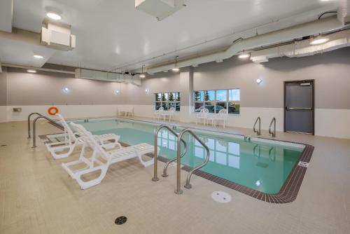 a swimming pool with chairs and a swimming pool at Hotel 11, MOD A Sonesta Collection in Calgary