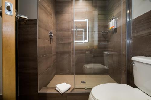a bathroom with a shower with a toilet at Hotel 11, MOD A Sonesta Collection in Calgary