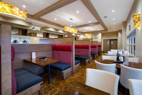a restaurant with red and blue seats and tables at Hotel 11, MOD A Sonesta Collection in Calgary