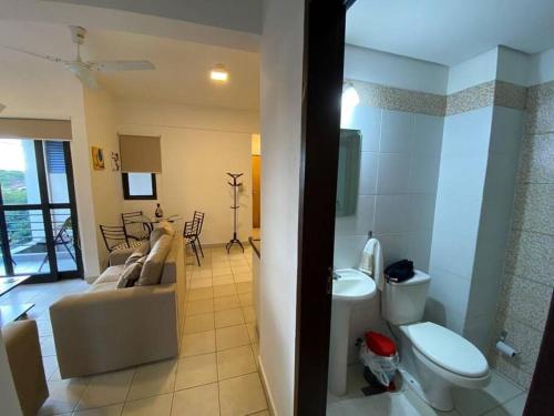 a bathroom with a toilet and a couch in a room at HERMOSO DPTO DE 2 DORMITORIOS CON GARAGE PRIVADO in San Lorenzo