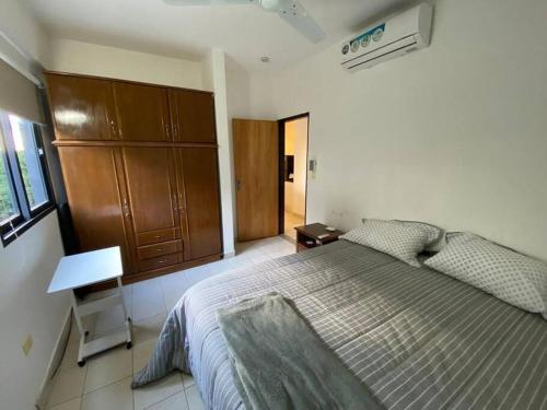 a bedroom with a large bed and a wooden cabinet at HERMOSO DPTO DE 2 DORMITORIOS CON GARAGE PRIVADO in San Lorenzo