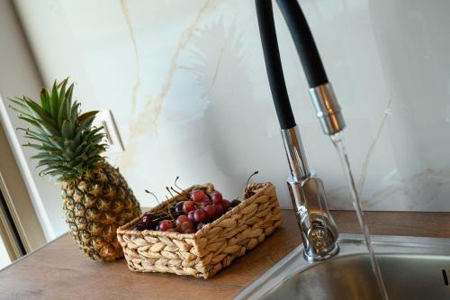 a basket of fruit on a counter next to a sink at LA MER Suite 2 in Matala
