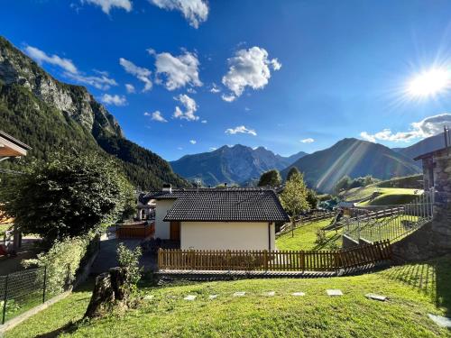 a house in a valley with mountains in the background at Baitèl - Tra il cielo e le Alpi in Gromo