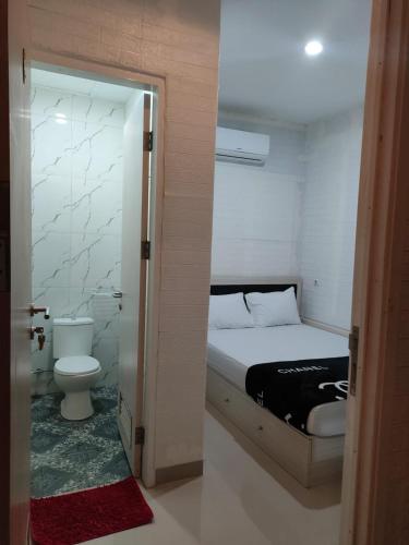 a small bedroom with a bed and a toilet at Cahaya Losmen Sragen Syariah in Sragen