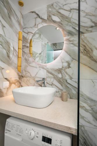 a bathroom with a white sink and a mirror at La MER 2 suite in Matala