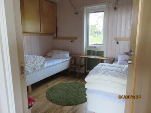 a small room with two beds and a window at Enebackens Kraftkälla in Tvååker