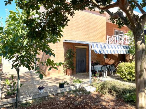 una casa con un porche con toldo azul en Uacella, en Locorotondo