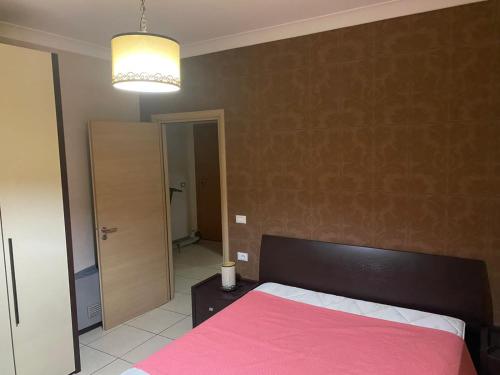 1 dormitorio con 1 cama con manta rosa en Vlora Stadium 2 BR Central Apartment, en Vlorë