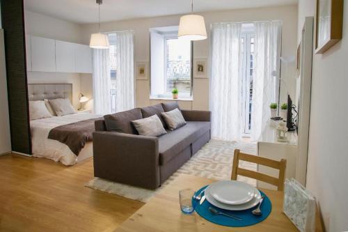 HÔTELS &ASPA في استوريل: غرفة معيشة مع أريكة وسرير وطاولة