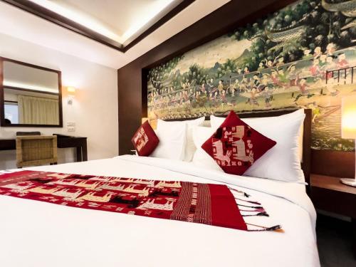 a bedroom with a large white bed with red pillows at City Inn Vientiane in Vientiane