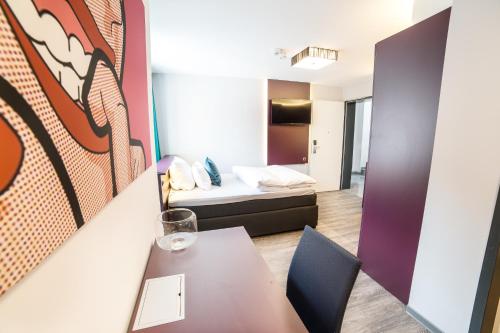 ein kleines Zimmer mit einem Tisch und einem Bett in der Unterkunft Luxstay Friedberg - Self-Check-In in Friedberg