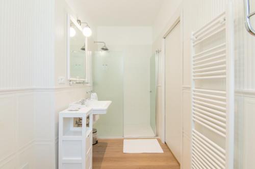 een witte badkamer met een wastafel en een douche bij B&B Villa Eden jacuzzi pool in Domaso