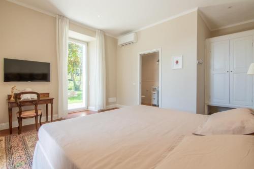 a bedroom with a large white bed and a window at B&B Villa Eden jacuzzi pool in Domaso