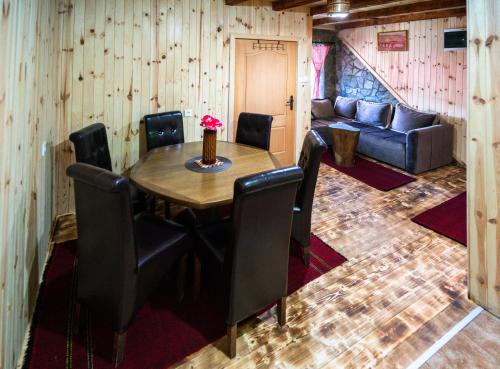 comedor con mesa, sillas y sofá en Country Villa MMMM, en Mojkovac