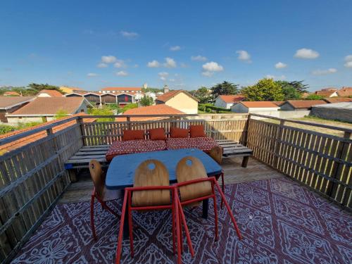 un toit-terrasse avec une table et des chaises dans l'établissement Super emplacement duplex climatisé, à Mimizan