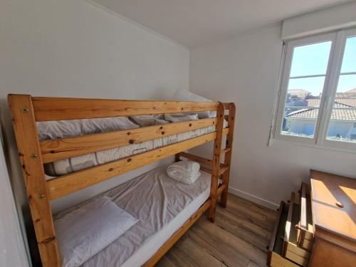 Ce lit superposé se trouve dans un dortoir doté d'une fenêtre. dans l'établissement Super emplacement duplex climatisé, à Mimizan