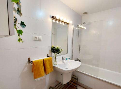 Un baño blanco con lavabo y ducha. en Masquestar Rías Altas, en Foz